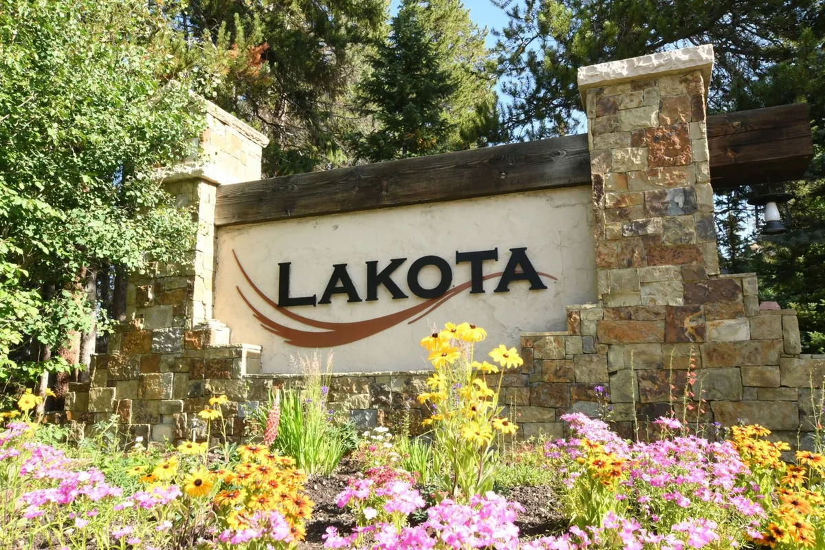 A welcoming entrance to the Lakota neighborhood, featuring prominent signage, flower beds, and stone columns. This image provides a sense of arrival and highlights the community's prestige and well-maintained environment.